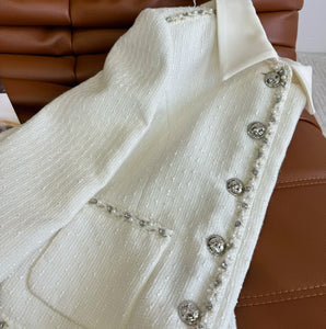 High end pearl trimmed short skirt set, featuring a short jacket paired with a high waisted skirt, exuding a luxurious  vibe